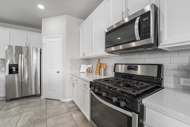 kitchen with white cabinets, decorative backsplash, light tile patterned flooring, and stainless steel appliances