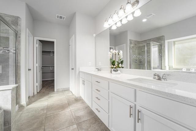 bathroom with tile patterned floors, vanity, and a shower with shower door