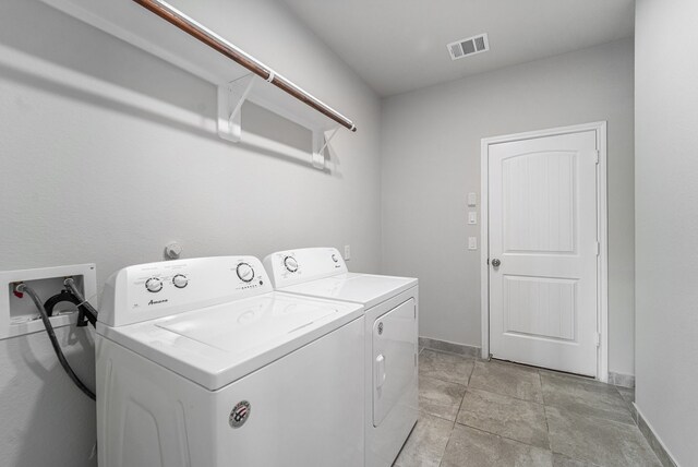 laundry room with washer and clothes dryer and light tile patterned flooring