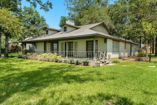 view of side of home with a lawn and a porch