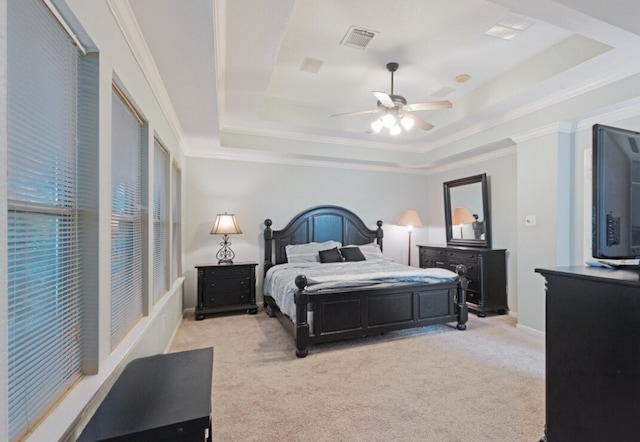 bedroom with light carpet, a raised ceiling, and ceiling fan