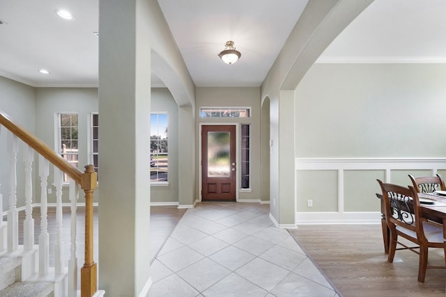 tiled foyer featuring crown molding