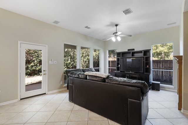 living room with ceiling fan, plenty of natural light, and light tile patterned flooring