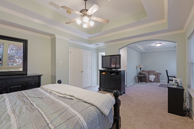 bedroom featuring light carpet, a raised ceiling, crown molding, ceiling fan, and multiple windows