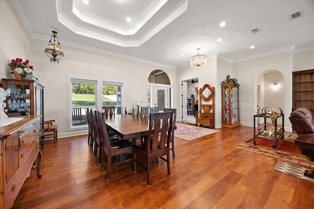 dining room featuring crown molding, hardwood / wood-style floors, and a notable chandelier