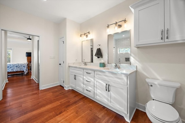 bathroom with hardwood / wood-style floors, vanity, ceiling fan, and toilet