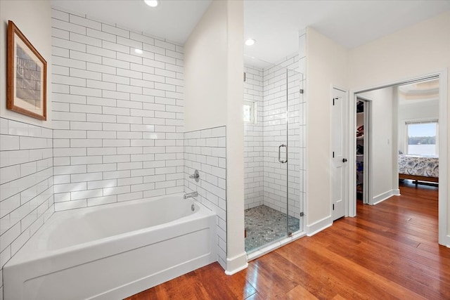 bathroom with hardwood / wood-style floors and independent shower and bath