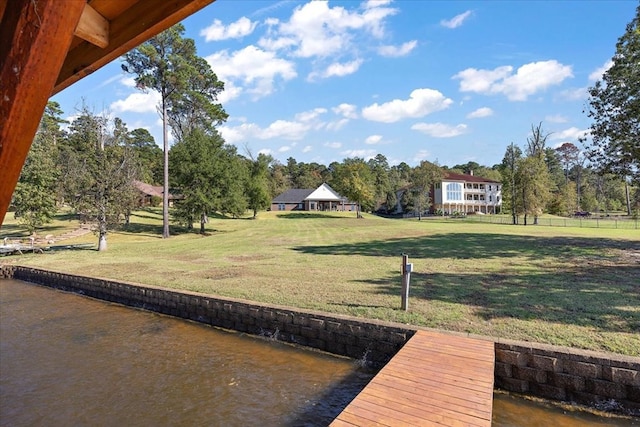 view of dock featuring a lawn