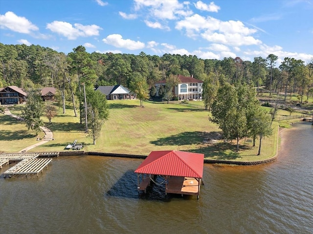 view of dock with a yard and a water view