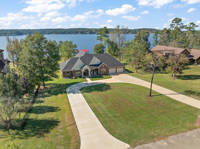 view of front of property with a garage, a water view, and a front yard