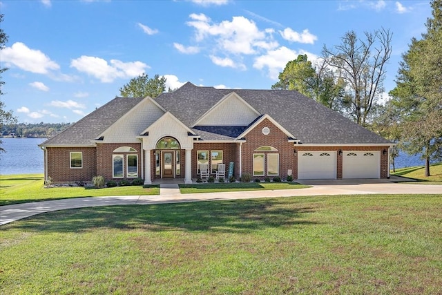 view of front of property featuring a garage, a water view, and a front yard