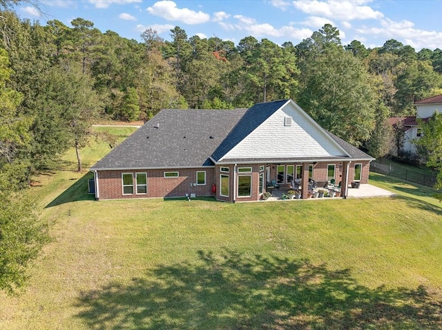 back of property with a patio area and a yard