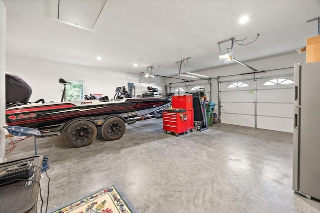 garage with stainless steel refrigerator and a garage door opener