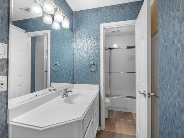 full bathroom featuring tile patterned flooring, vanity, enclosed tub / shower combo, and toilet