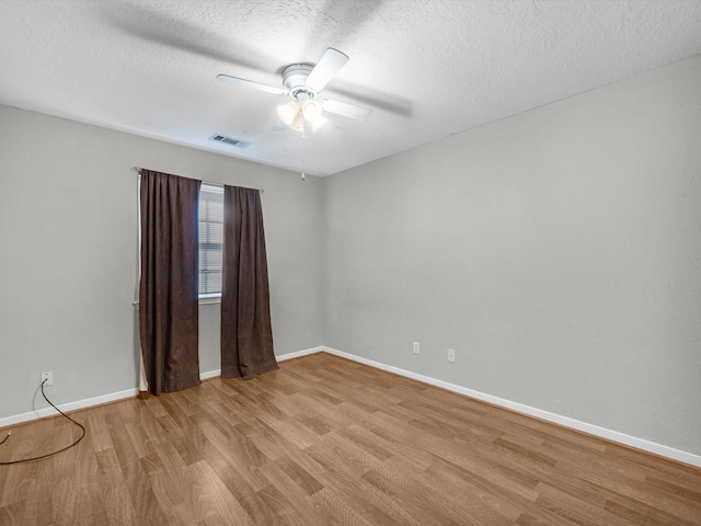 unfurnished room with ceiling fan, light hardwood / wood-style floors, and a textured ceiling