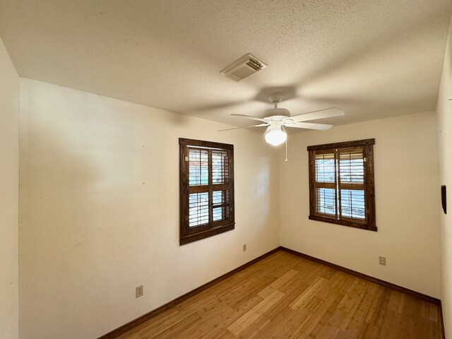 unfurnished room featuring a textured ceiling, light hardwood / wood-style flooring, ceiling fan, and a healthy amount of sunlight