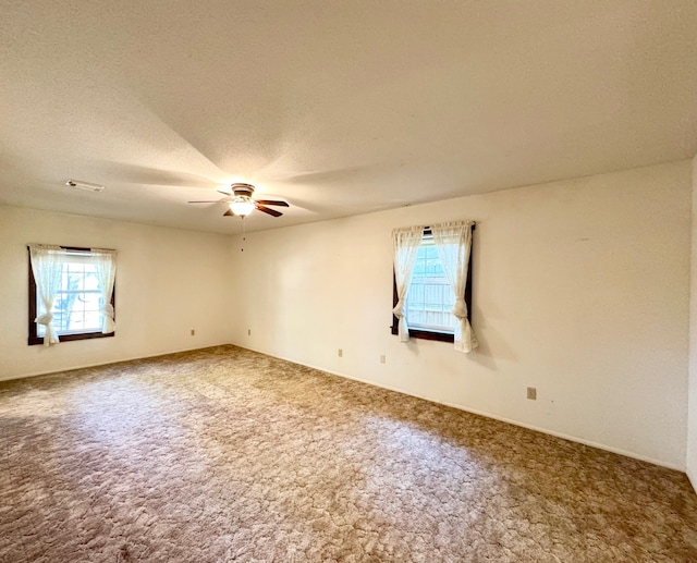 carpeted empty room with a textured ceiling and ceiling fan