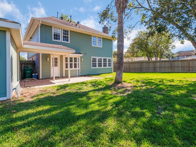 back of house with a patio area and a yard