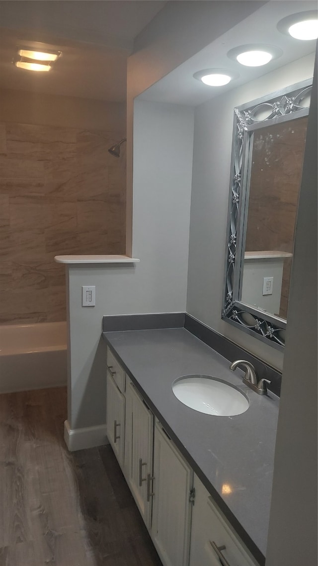 bathroom with shower / bathing tub combination, vanity, and hardwood / wood-style flooring