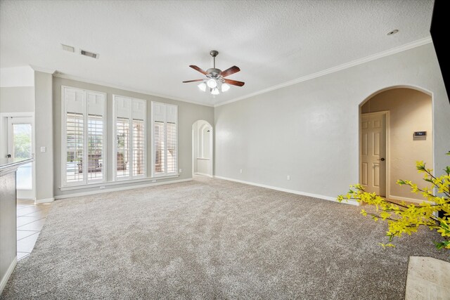 carpeted empty room featuring ceiling fan, a textured ceiling, and ornamental molding