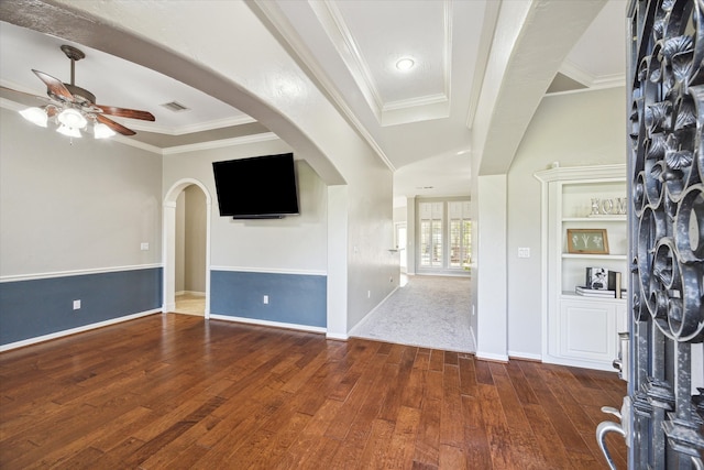 unfurnished living room with dark hardwood / wood-style flooring, ceiling fan, and crown molding