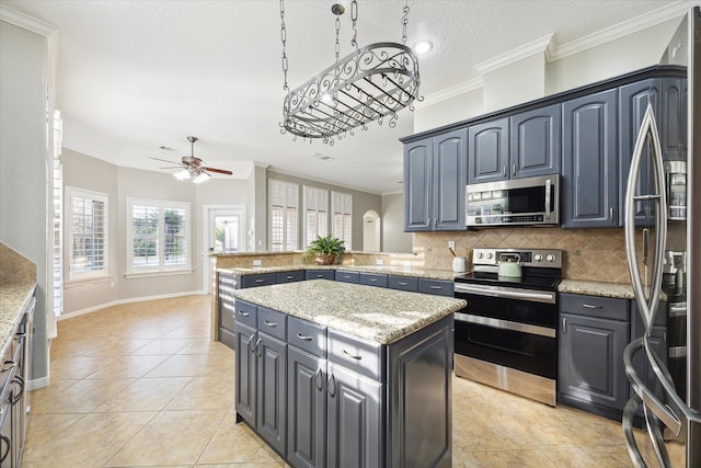 kitchen with light stone countertops, stainless steel appliances, a textured ceiling, decorative backsplash, and a kitchen island