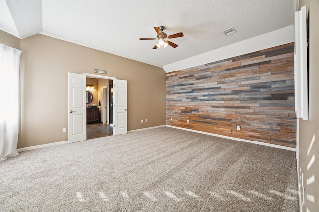 unfurnished bedroom with dark colored carpet, ceiling fan, lofted ceiling, and a textured ceiling