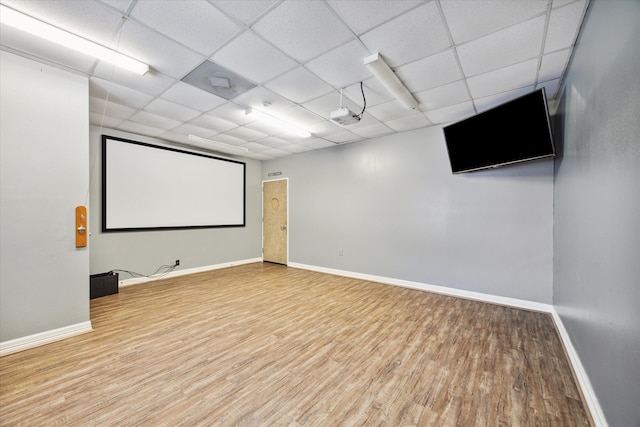 home theater featuring hardwood / wood-style floors and a paneled ceiling