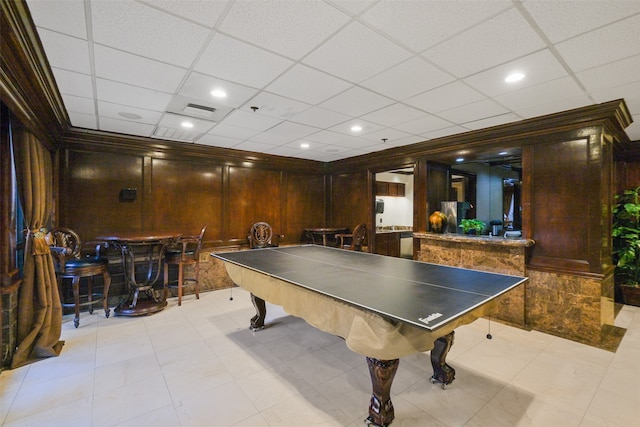 playroom with a drop ceiling and wooden walls