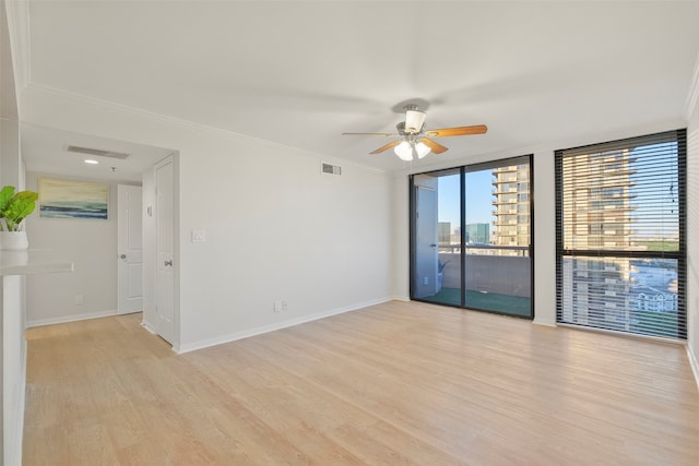 empty room with ceiling fan, light hardwood / wood-style flooring, expansive windows, and ornamental molding