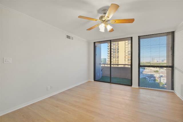 empty room featuring ceiling fan, light hardwood / wood-style floors, and crown molding