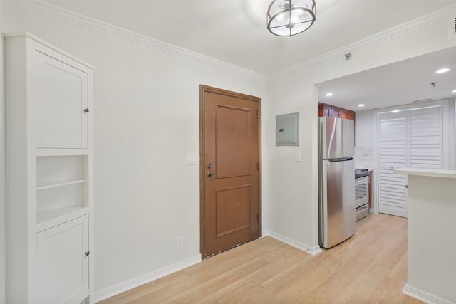 kitchen with light wood-type flooring, stainless steel appliances, electric panel, and ornamental molding