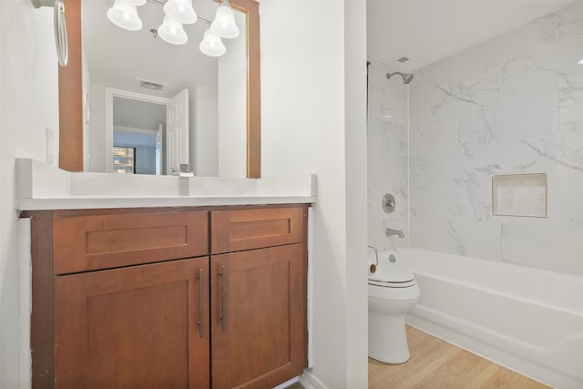 full bathroom featuring wood-type flooring, vanity, toilet, and tiled shower / bath