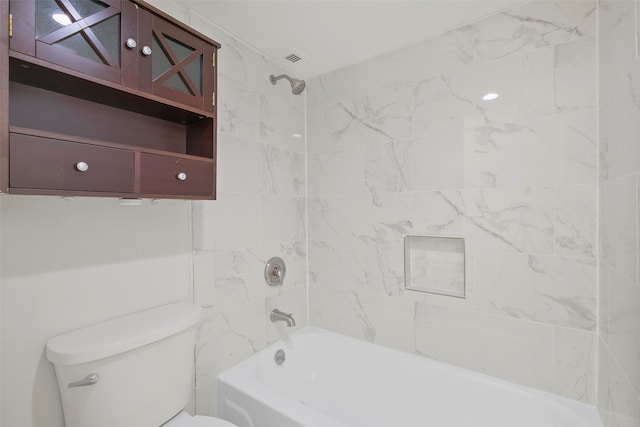 bathroom featuring toilet and tiled shower / bath