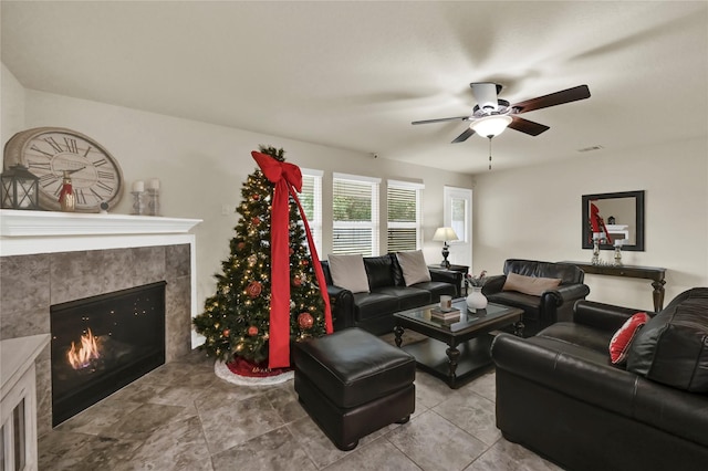 living room with ceiling fan and a fireplace