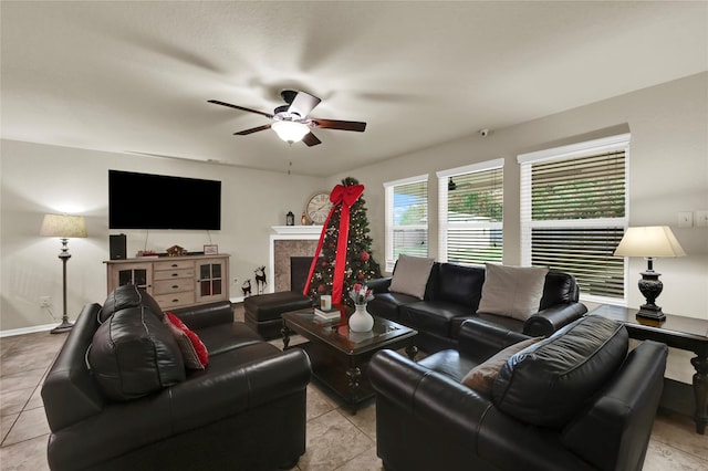 tiled living room with ceiling fan and a fireplace