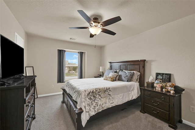 carpeted bedroom featuring ceiling fan and a textured ceiling