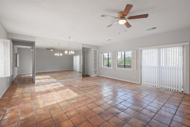 empty room featuring a textured ceiling, ceiling fan with notable chandelier, and tile patterned floors