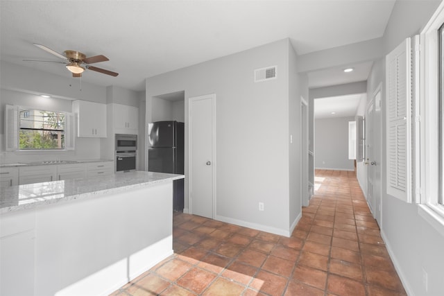 kitchen with white cabinets, appliances with stainless steel finishes, tile patterned floors, and ceiling fan