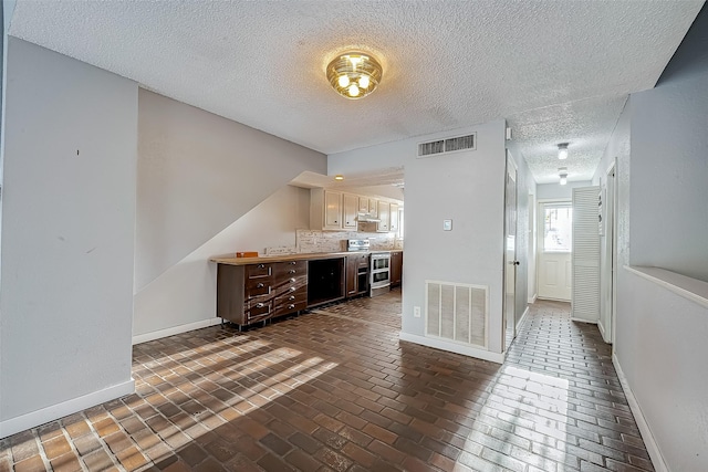 bar featuring visible vents, double oven range, and baseboards