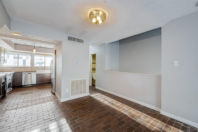 kitchen featuring visible vents, stainless steel appliances, light countertops, and baseboards