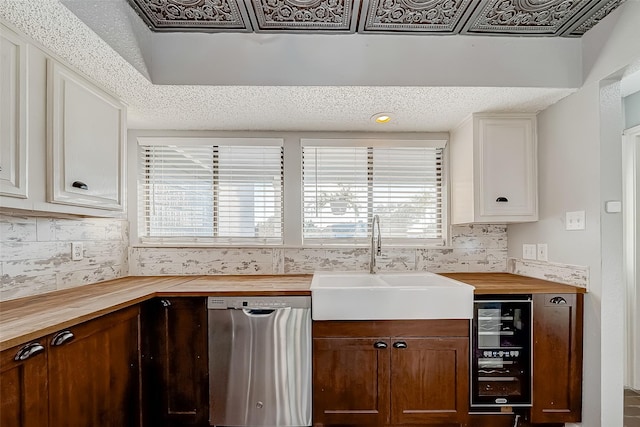 kitchen with a sink, stainless steel dishwasher, butcher block countertops, and beverage cooler