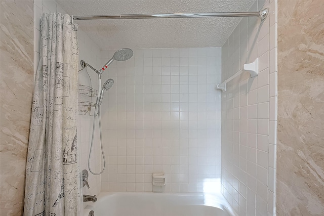 full bath with a textured ceiling and shower / tub combo