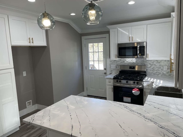 kitchen with light stone countertops, hanging light fixtures, lofted ceiling, white cabinets, and appliances with stainless steel finishes