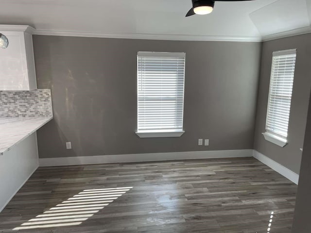 unfurnished dining area with a healthy amount of sunlight, dark hardwood / wood-style flooring, and crown molding