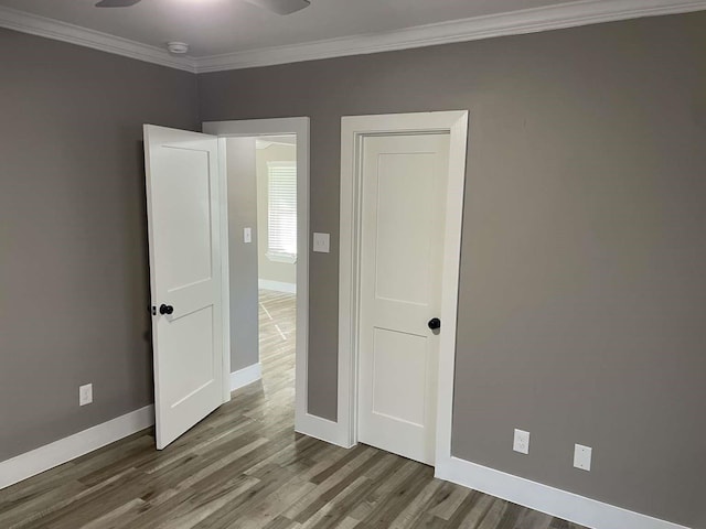 unfurnished bedroom featuring hardwood / wood-style floors, ceiling fan, and crown molding