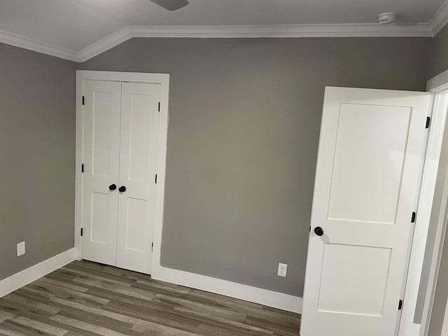 unfurnished bedroom featuring hardwood / wood-style floors, a closet, and crown molding