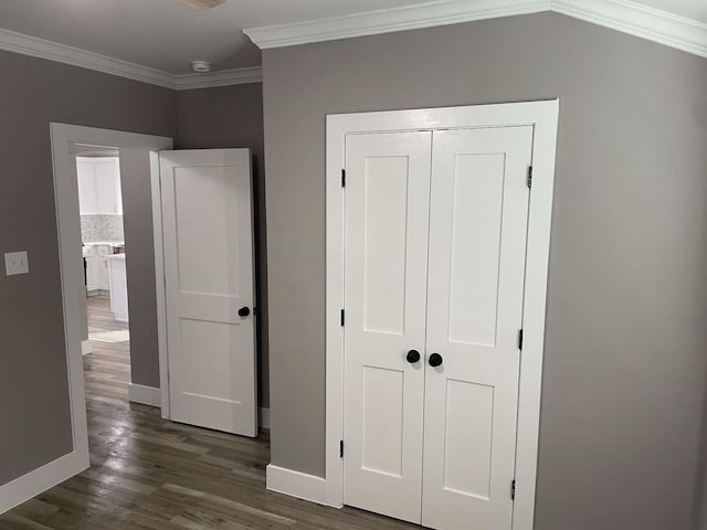 unfurnished bedroom with dark hardwood / wood-style flooring, a closet, and crown molding