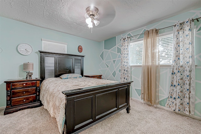 carpeted bedroom with ceiling fan and a textured ceiling