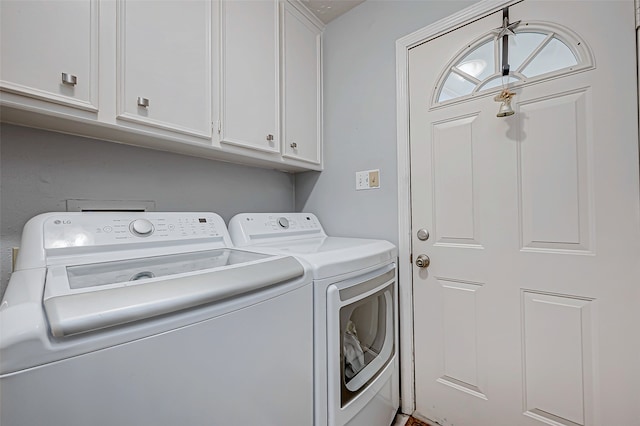 clothes washing area with cabinets and washing machine and dryer